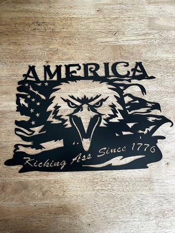 Metal sign with an eagle and flag that reads America kicking ass since 1776